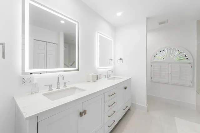 a bathroom with double vanity sink and a mirror