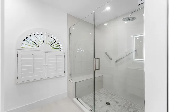 a bathroom with a shower and a glass door