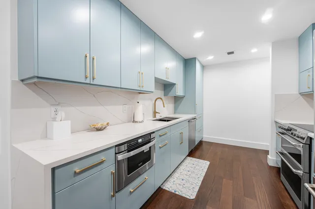 a kitchen with a sink a stove and cabinets