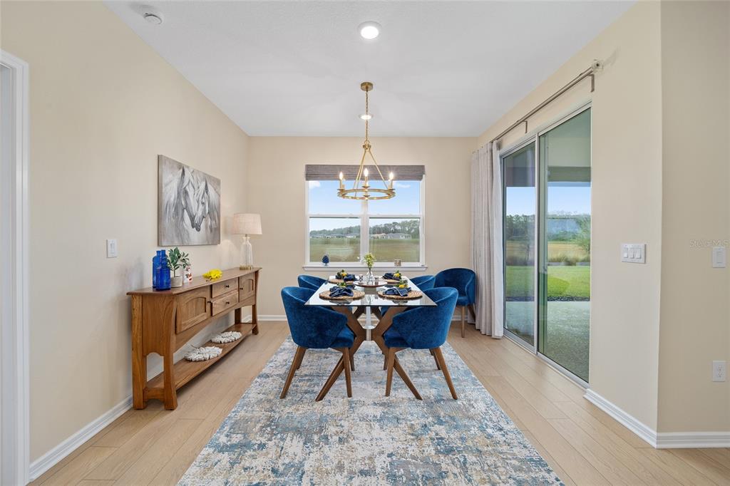 8491 Southwest 52nd Ln Road Ocala, FL 34481 - Photo 17 of 45 a dining room with furniture a rug and wooden floor