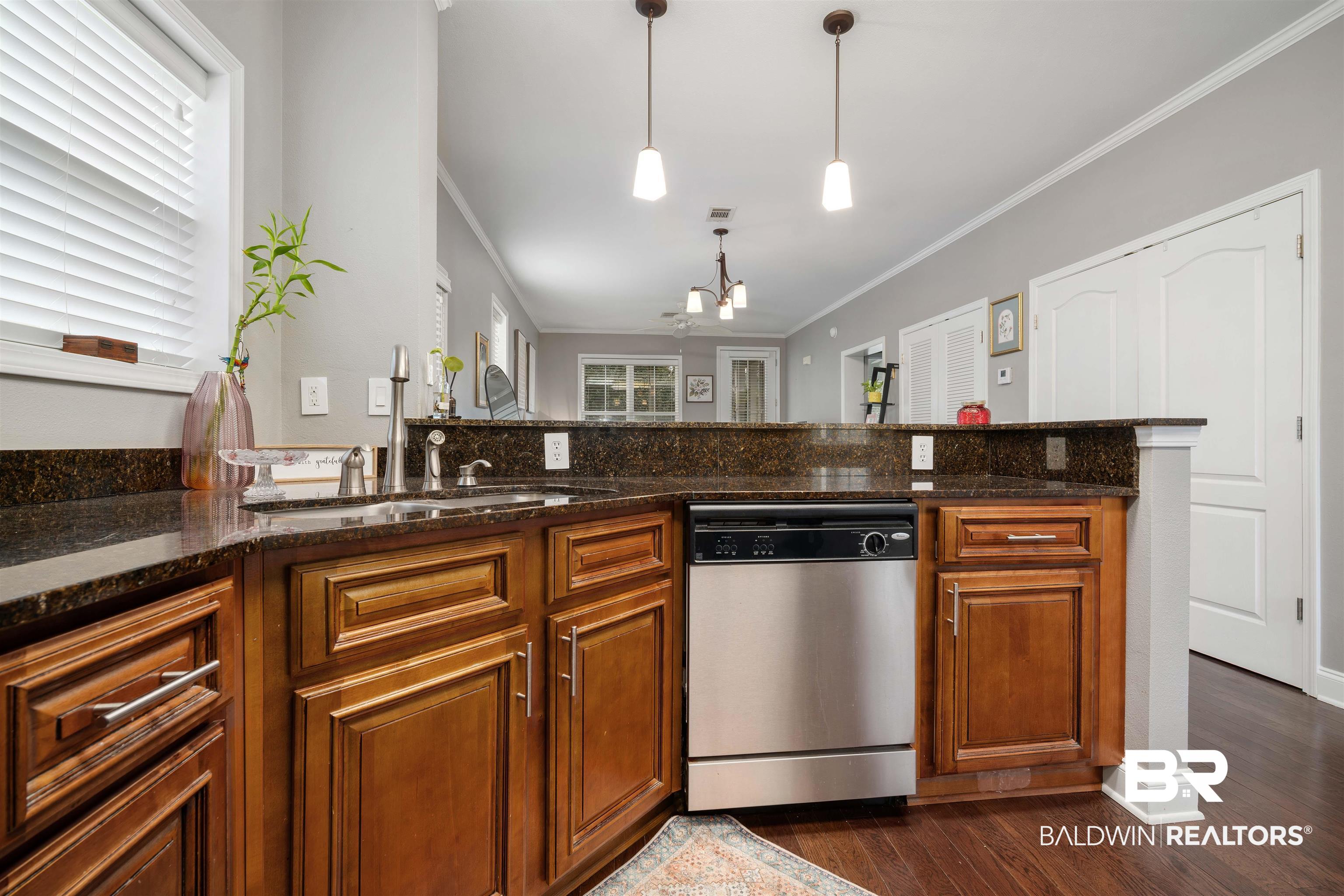 25806 Pollard Road, Unit 205 Daphne, AL 36526 - Photo 10 of 26 Kitchen with wood finish cabinetry, hanging lights, dishwasher, dark stone countertops, and crown molding