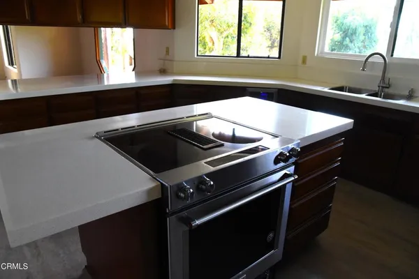 a close up of a sink a stove and a window