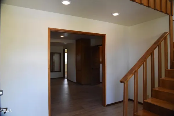 a view of a hallway with wooden floor and stairs