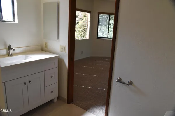 a bathroom with a granite countertop sink and mirror