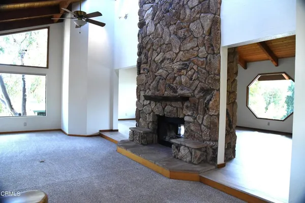 an empty room with a fireplace and wooden floor