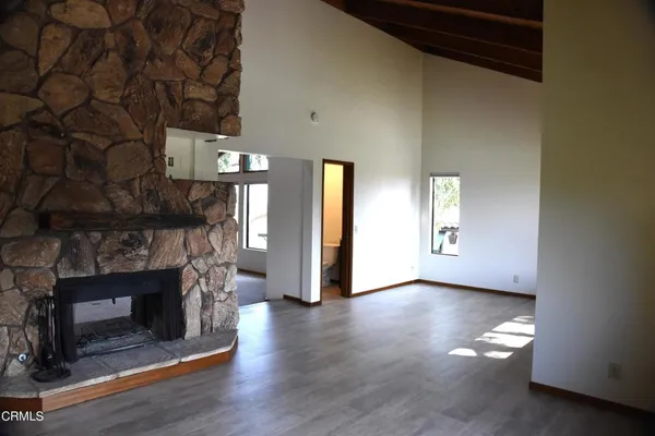 a view of a livingroom with wooden floor a fireplace and window