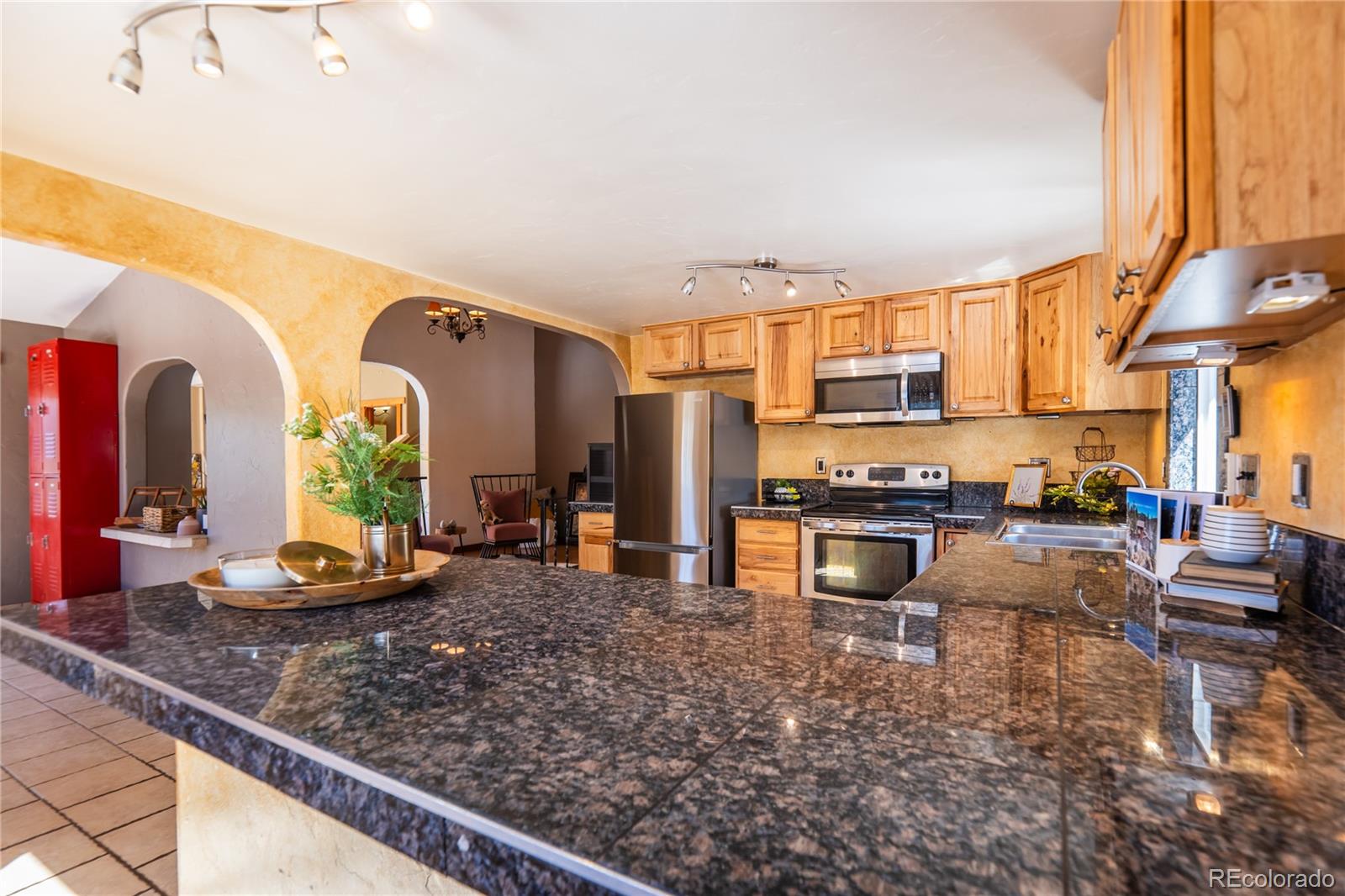 252 Jones Road Bailey, CO 80421 - Photo 6 of 36 a kitchen with stainless steel appliances granite countertop a stove top oven a sink dishwasher a dining table and chairs with wooden floor