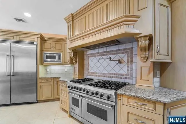 a kitchen with granite countertop a stove a sink and a microwave