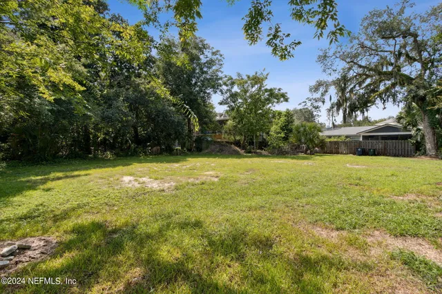 a view of yard with swimming pool and green space