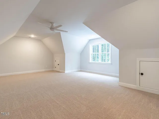 an empty room with windows and chandelier fan