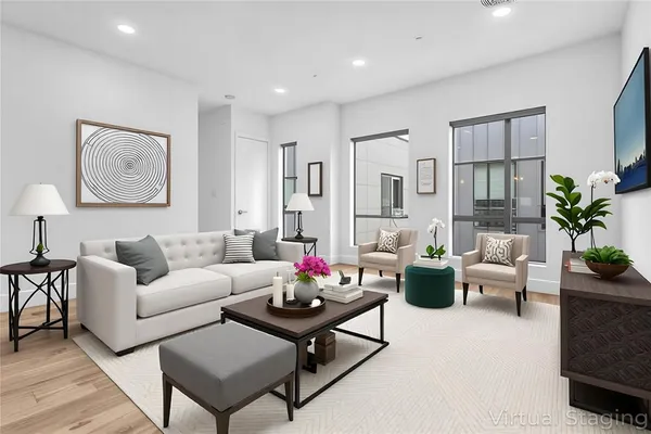a living room with furniture potted plant and kitchen view