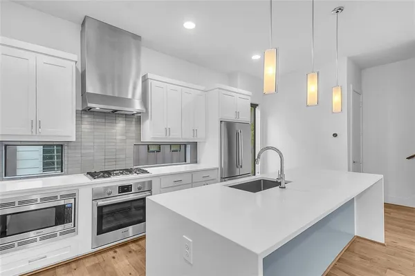 a kitchen with a sink a stove and cabinets