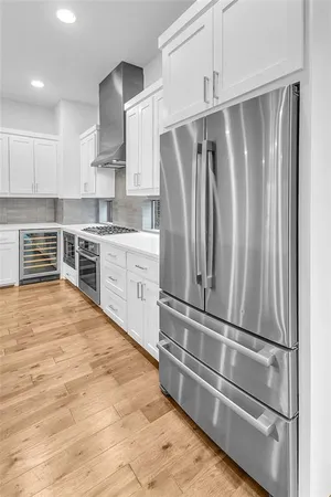 a kitchen with granite countertop a refrigerator and cabinets