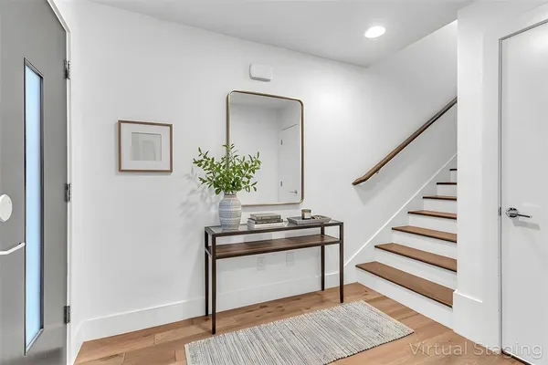 a view of a hallway with wooden floor and entryway