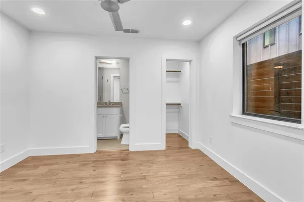 a view of empty room with wooden floor and windows
