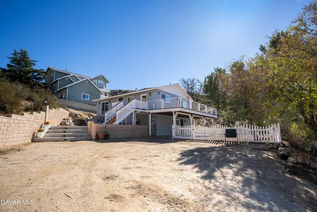 a kitchen with stainless steel appliances kitchen island granite countertop a refrigerator a stove and a wooden floors