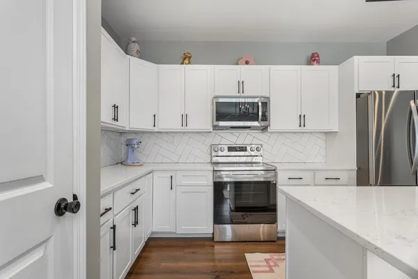 a kitchen with cabinets stainless steel appliances and sink
