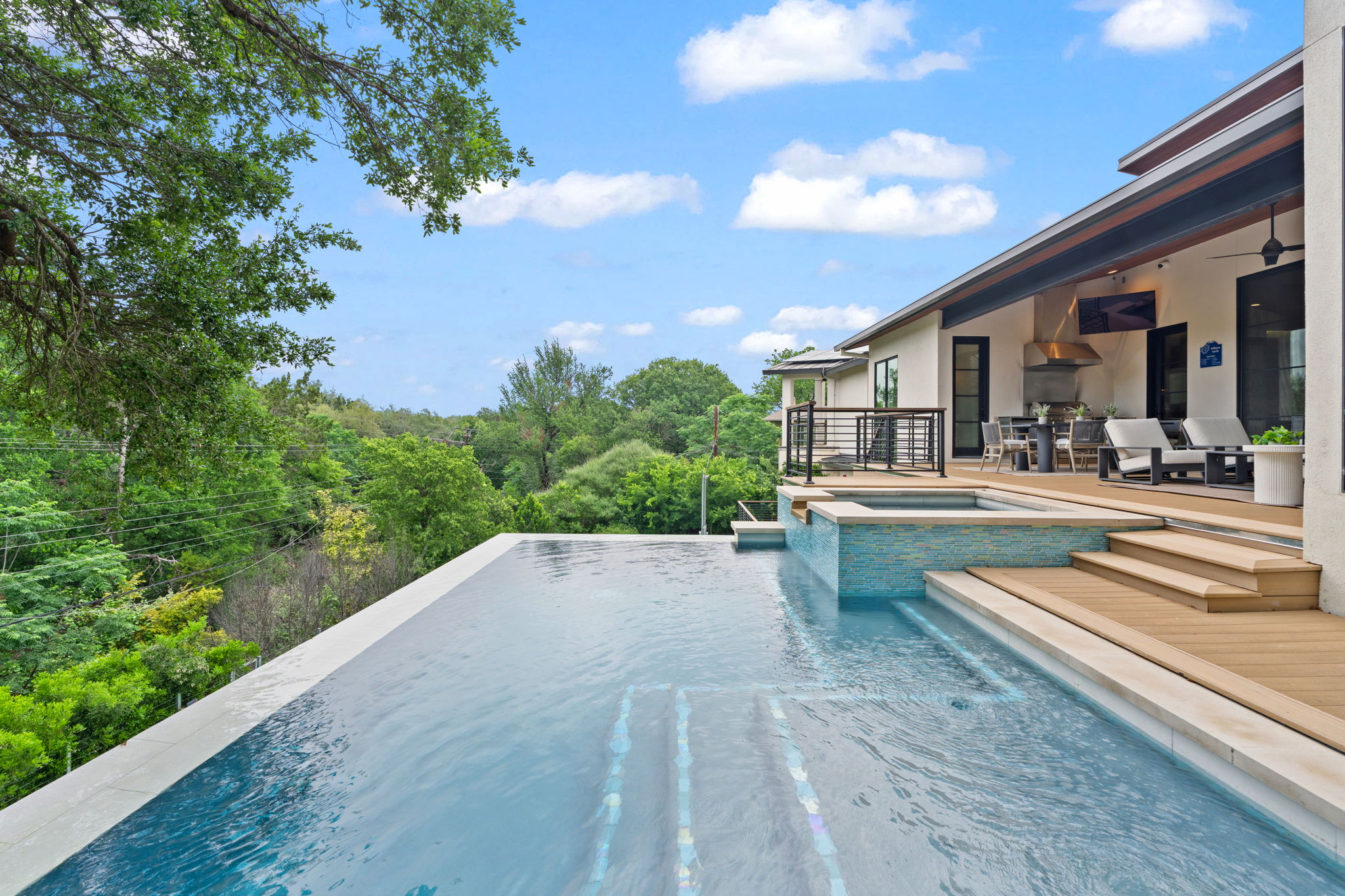 604 Brookhaven Trail Austin, TX 78746 - Photo 29 of 38 Infinity-edge pool with integrated spa and wood-finish decking.