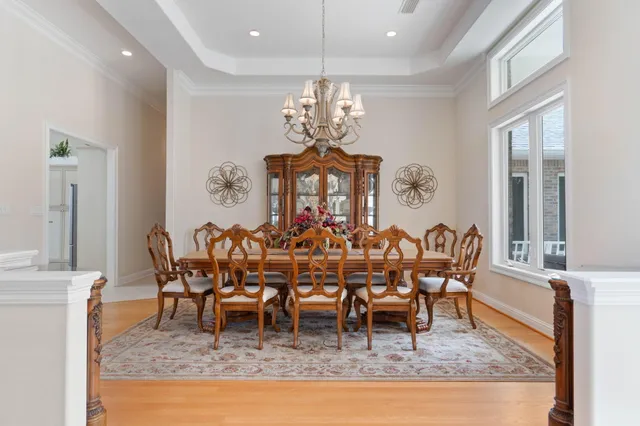 a spacious bedroom with a bed a chandelier and a couch