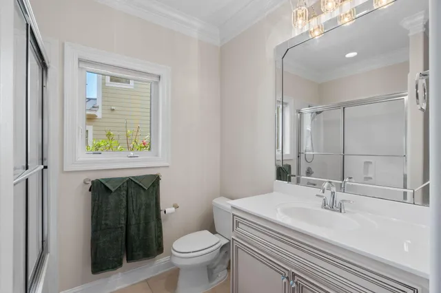 a front view of a house with a yard and potted plants