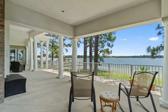 a dining room with wooden floor a chandelier a wooden table and chairs