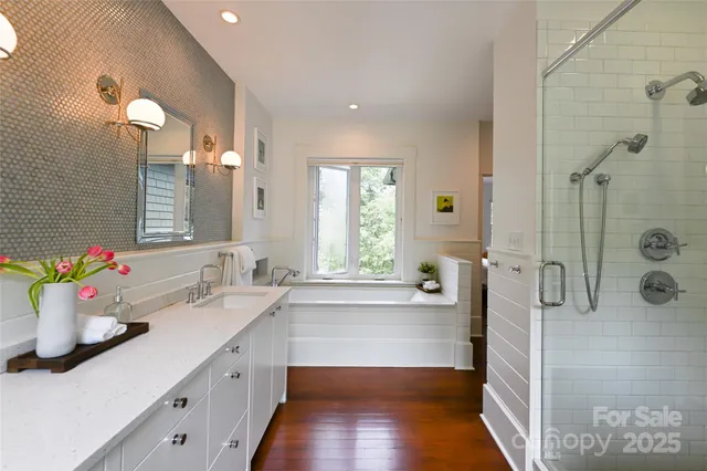 a bathroom with a tub sink and mirror