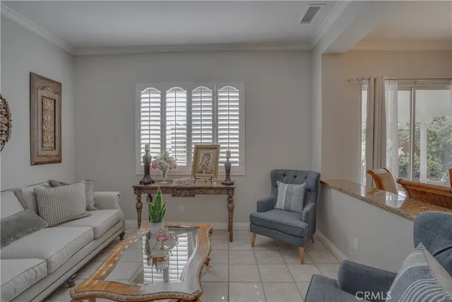 a living room with furniture a flat screen tv and a chandelier