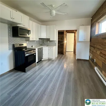 a kitchen with granite countertop wooden floors and stainless steel appliances
