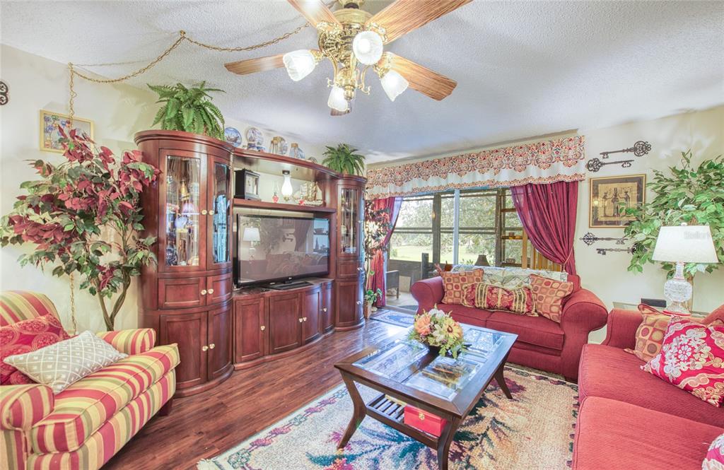 7040 Cognac Drive, Unit 3 New Port Richey, FL 34653 - Photo 18 of 31 a living room with furniture a chandelier and a flat screen tv