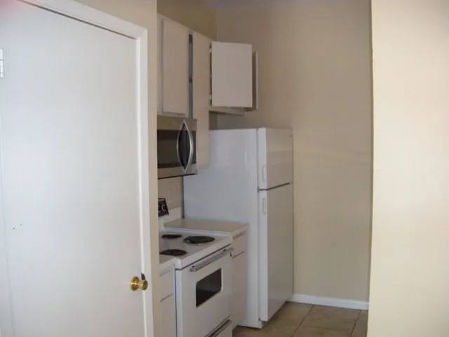 a kitchen with a refrigerator stove and microwave