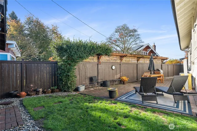 a view of backyard with seating space and trees in the background