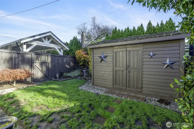a backyard of a house with plants and wooden fence