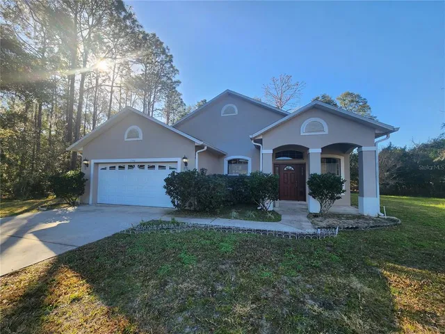 a front view of a house with a yard and garage