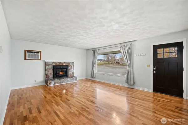 a view of empty room with wooden floor and fireplace