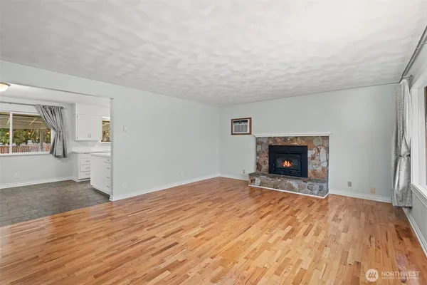 a view of empty room with wooden floor and fireplace