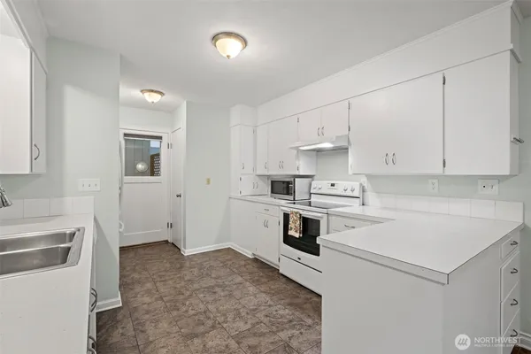 a kitchen with white cabinets and white appliances