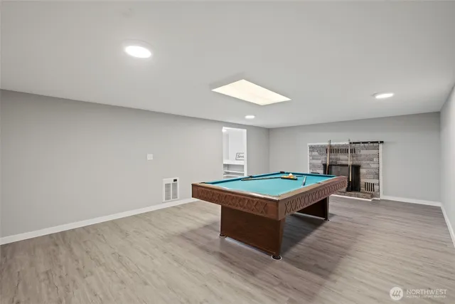 a room with wooden floor and pool table