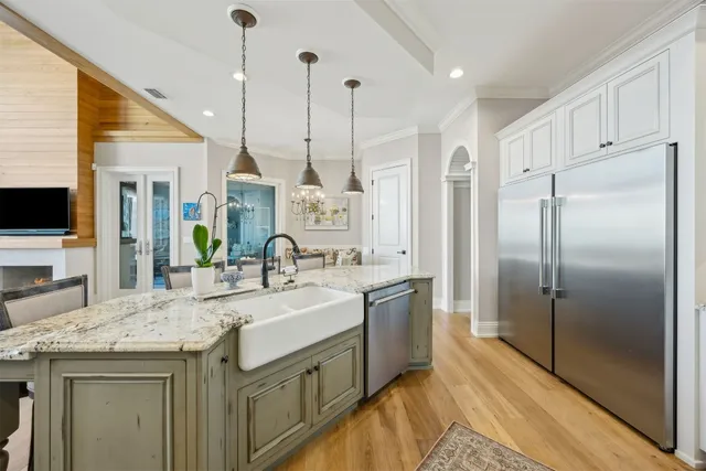 a kitchen with stainless steel appliances kitchen island granite countertop a sink cabinets and wooden floor
