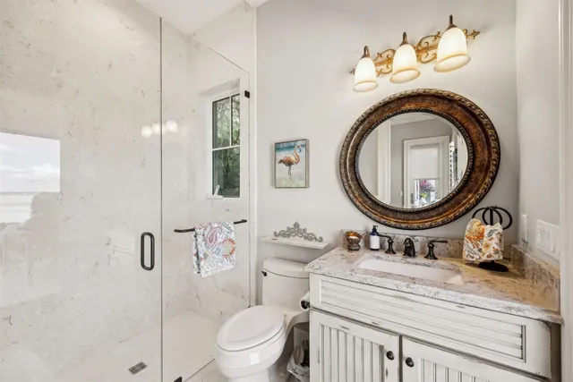 a bathroom with a granite countertop sink toilet and shower