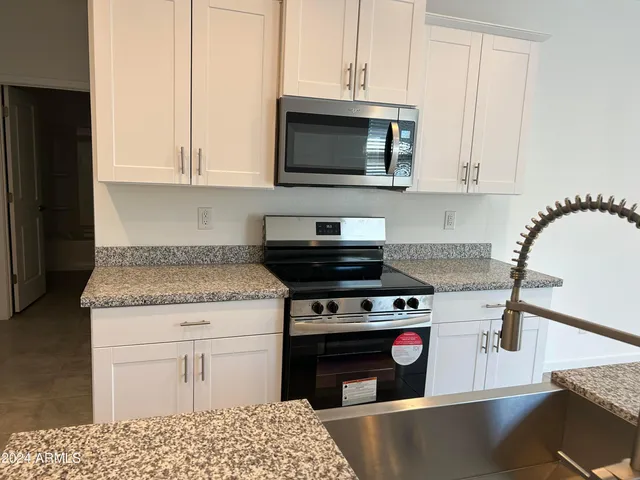 a kitchen with stainless steel appliances granite countertop a stove a microwave and cabinets