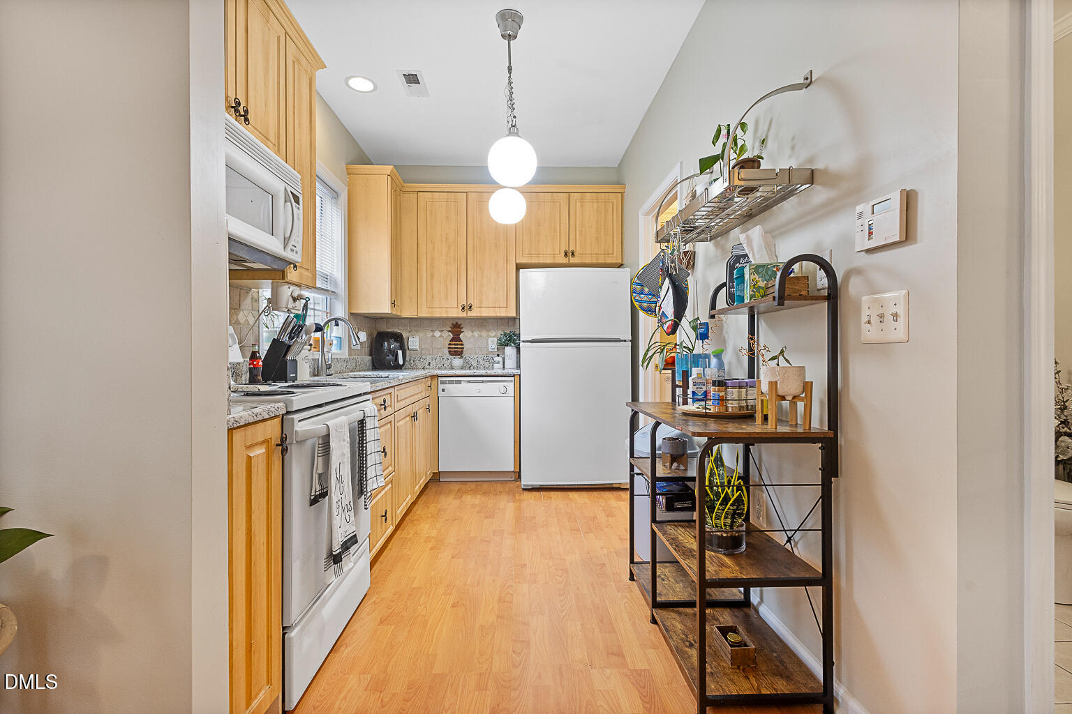 2907 Andover Glen Road Raleigh, NC 27604 - Photo 13 of 39 a kitchen with kitchen island granite countertop wooden cabinets and refrigerator