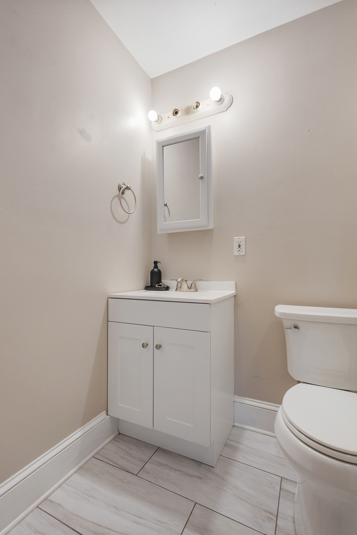 222 West Main Street, Unit A St. Charles, IL 60174 - Photo 16 of 17 a bathroom with a toilet sink vanity and mirror