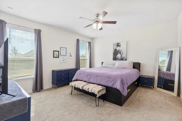 a spacious bedroom with a bed chandelier and a window