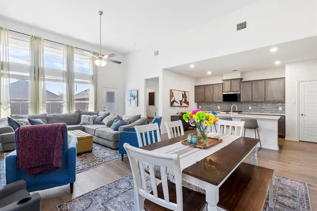 a view of a dining room and livingroom with furniture wooden floor a chandelier