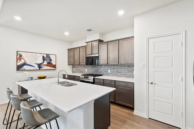 a kitchen with a sink cabinets and wooden floor