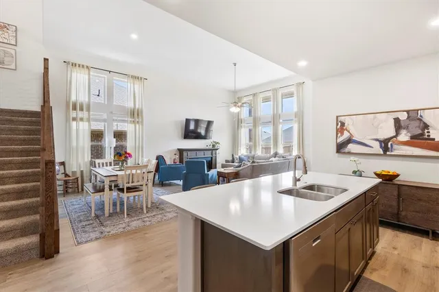 a kitchen with stainless steel appliances granite countertop a sink a stove and white cabinets with wooden floor