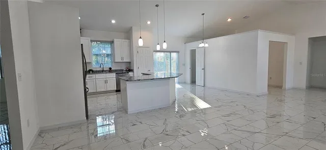a kitchen with a refrigerator a sink and a stove top oven with wooden floor
