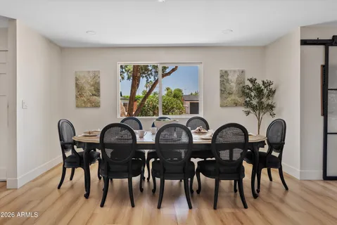 a view of a a dining room with furniture window and wooden floor