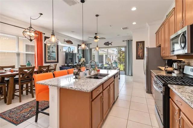 a kitchen with stainless steel appliances granite countertop a sink a stove and a wooden floors