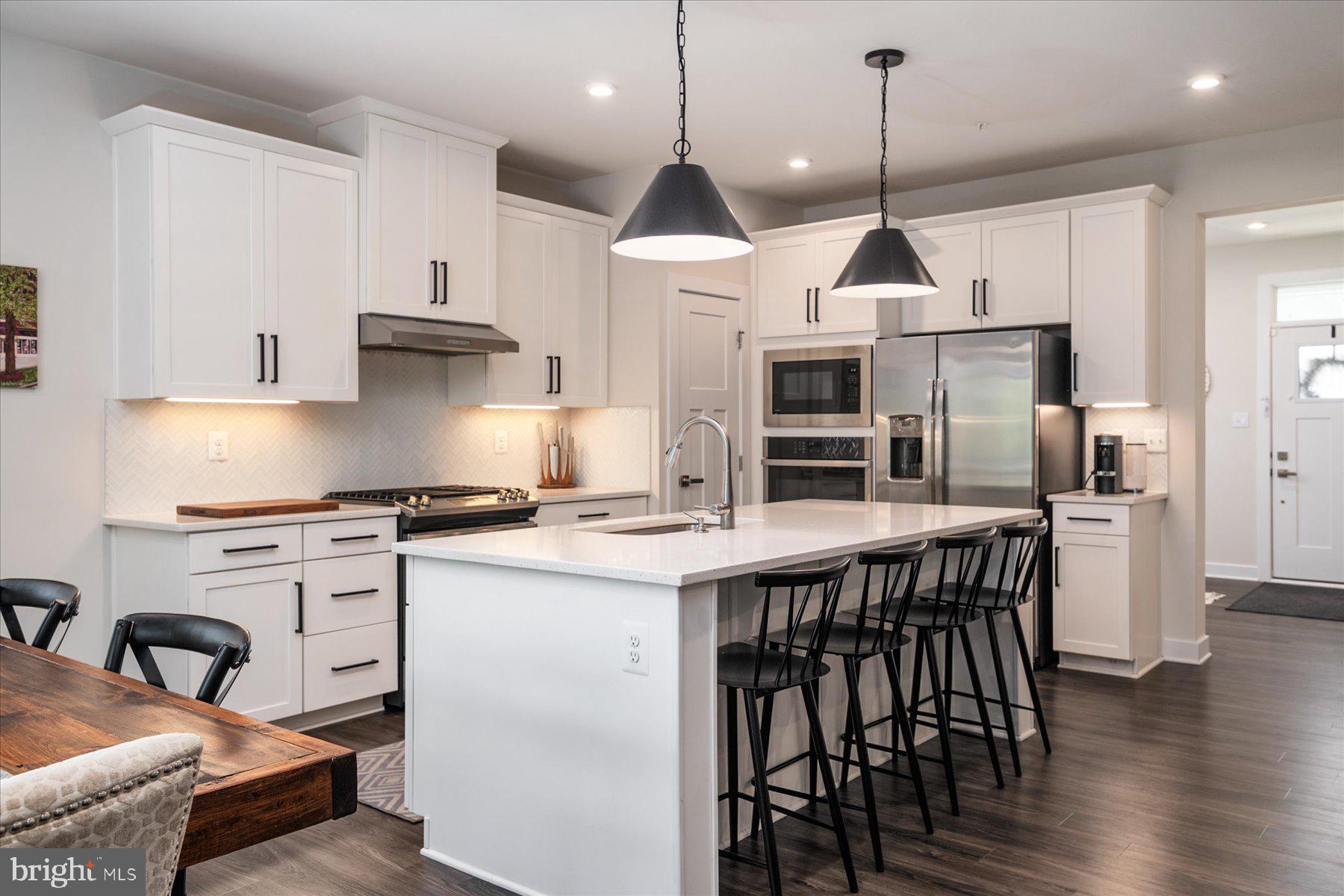 1261 Upper Patuxent Ridge Road Odenton, MD 21113 - Photo 2 of 58 a kitchen with stainless steel appliances granite countertop a stove a kitchen island a stove and a wooden floors
